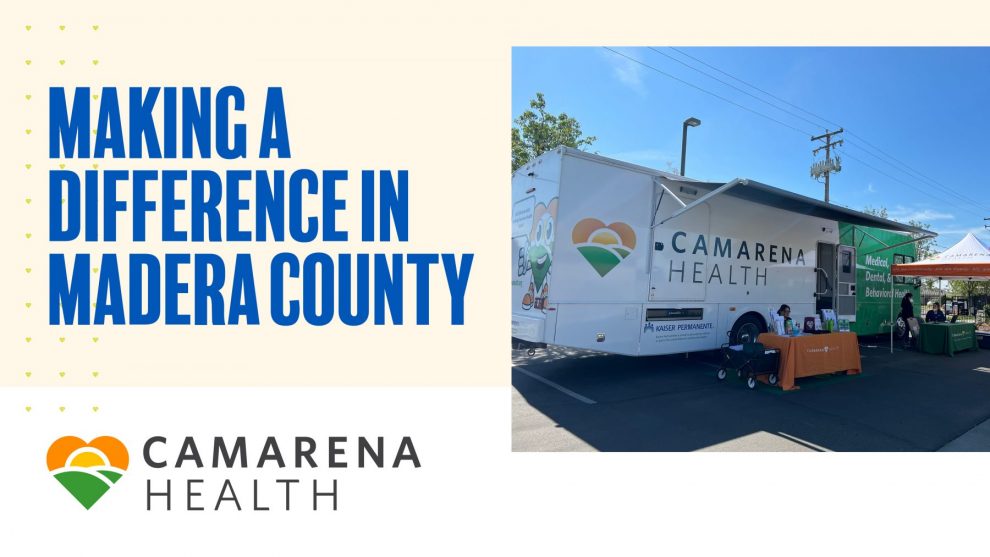 Clínica móvil de Camarena Health aparcada al aire libre en un evento, con personal en mesas bajo carpas y un cartel que dice "Marcando la diferencia en el condado de Madera". El logotipo de Camarena Health también es visible.